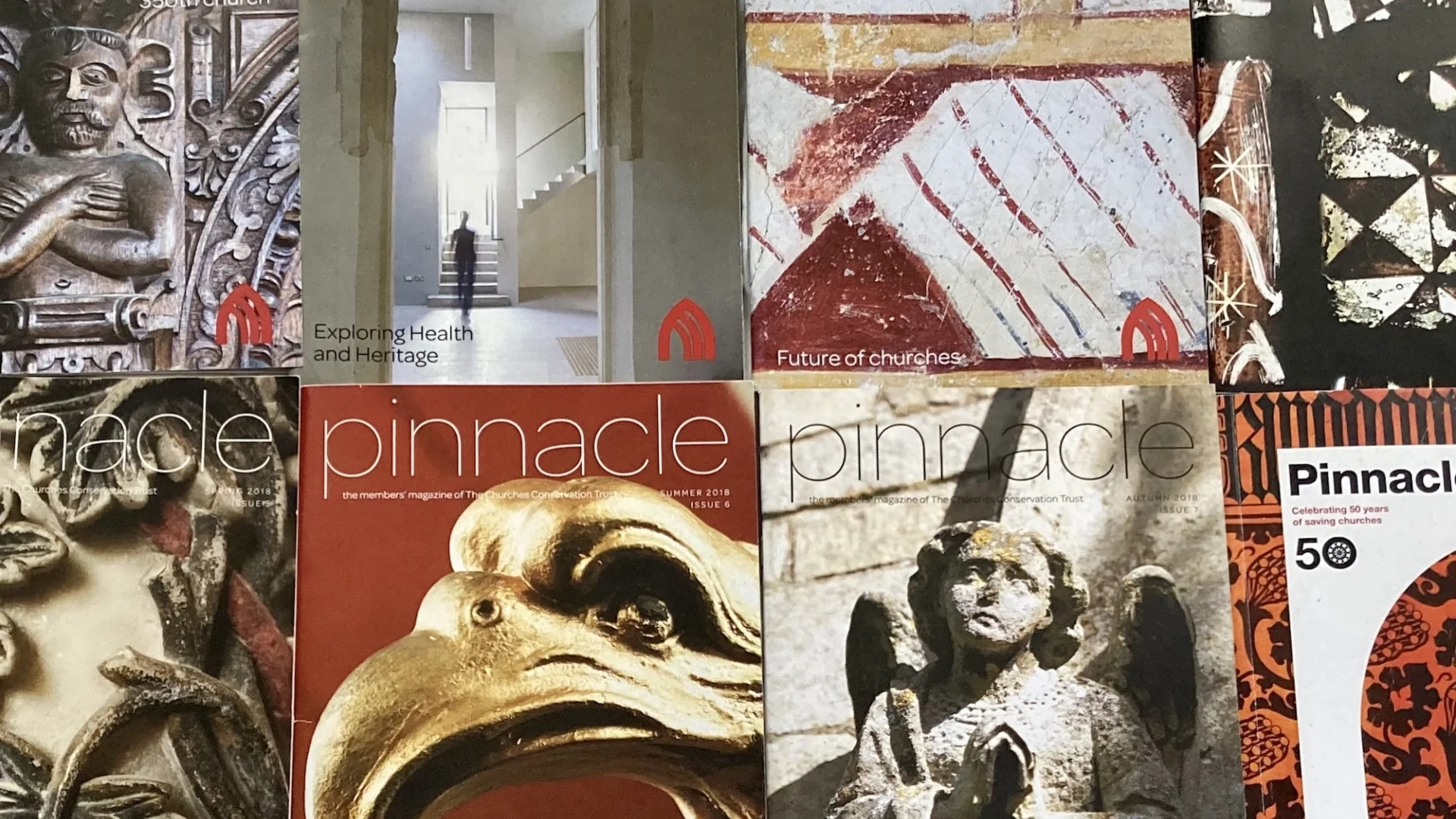Front covers of eight pinnacle magazines with front-page images of church angels and wall paintings