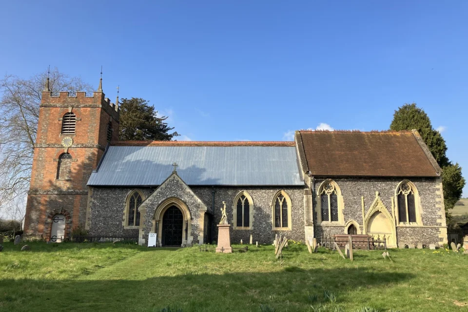 Photo of a stone church with a steel roof covering the Nave to protect it from the elements.