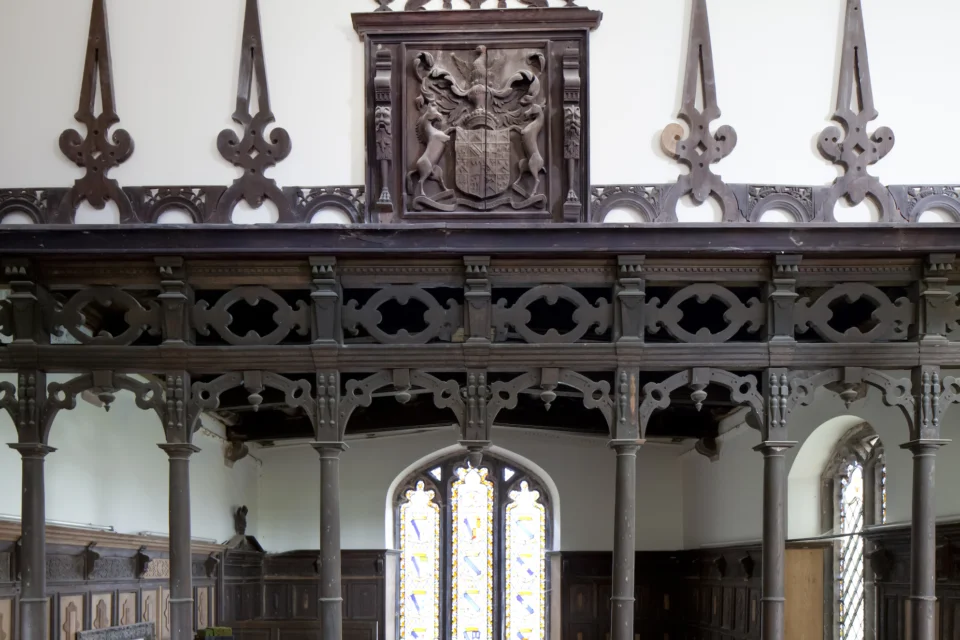 Pews facing towards the dark wood 17th-century decorative screen