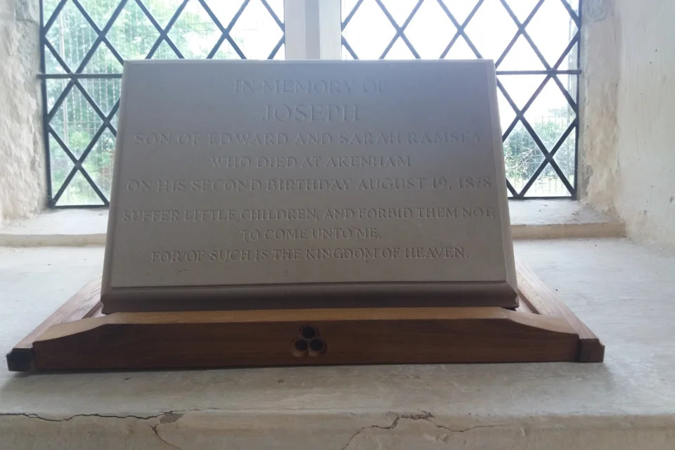 Gravestone with inscription: 'In Memory of Joseph Son of Edward and Sarah Ramsey who Died at Akenham on his Second Birthday August 19,1878. Suffer Little Children, and Forbid them not to Come onto me for of such is the Kingdom of Heaven.'