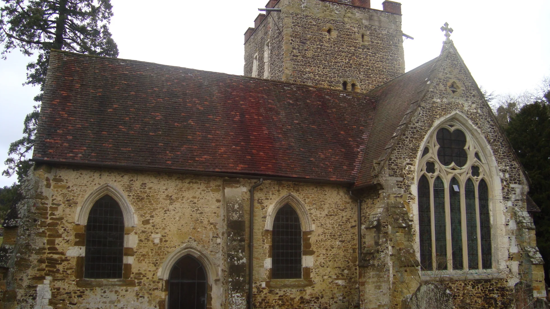 Image of  flint-walled church exterior and graveyard