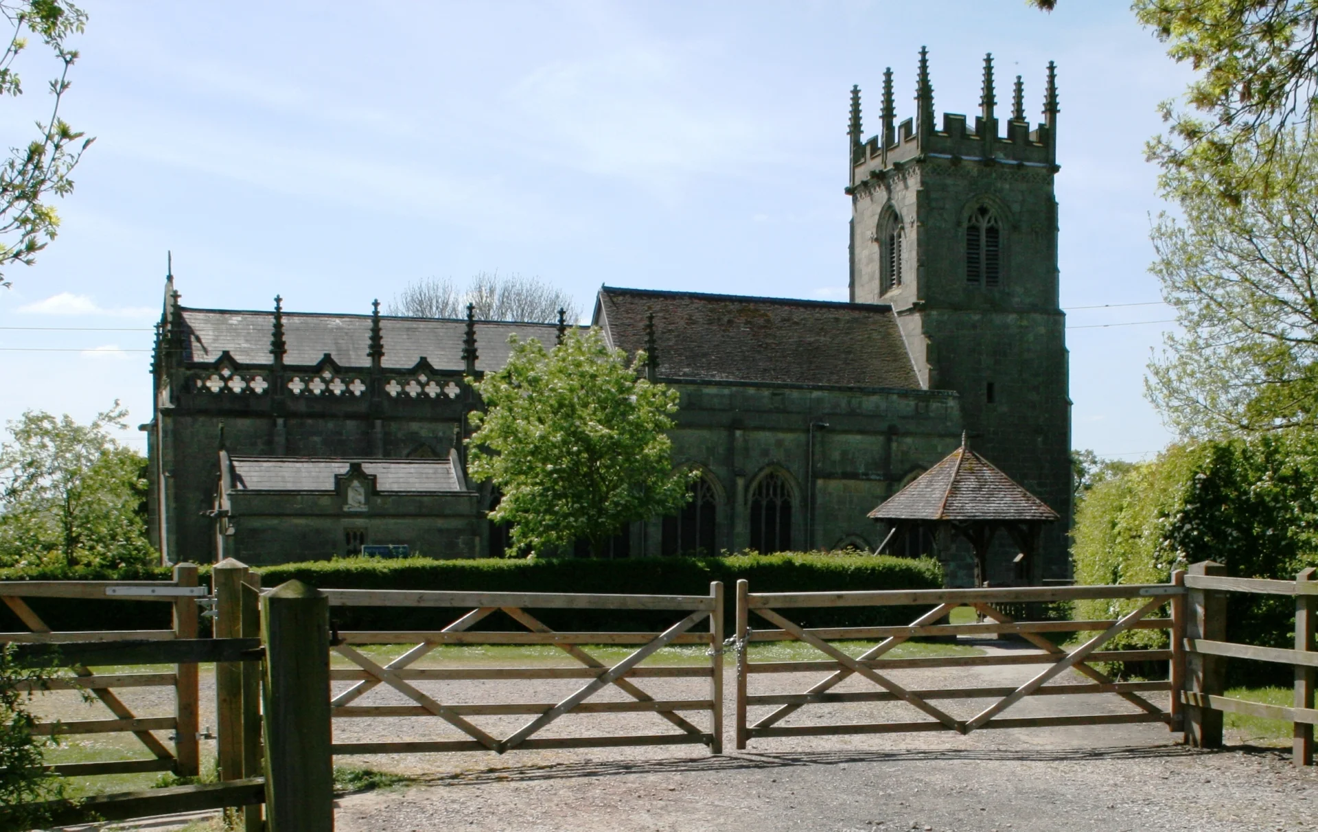 A large church exterior behind wooden gate