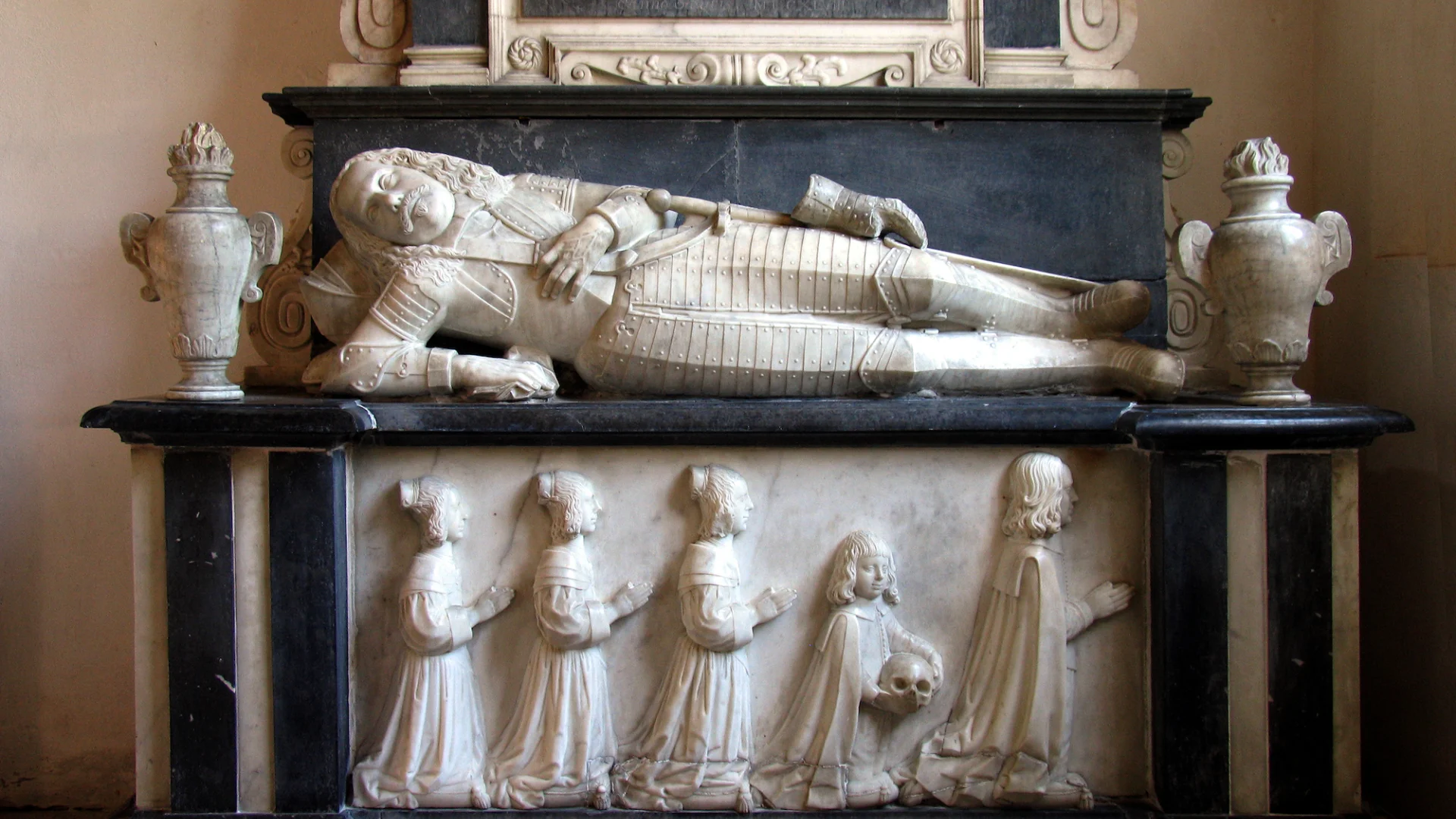 monument to the dashing figure of Sir Henry Audley (who died in 1648), reclining stiffly in his armour with his children kneeling beneath him.