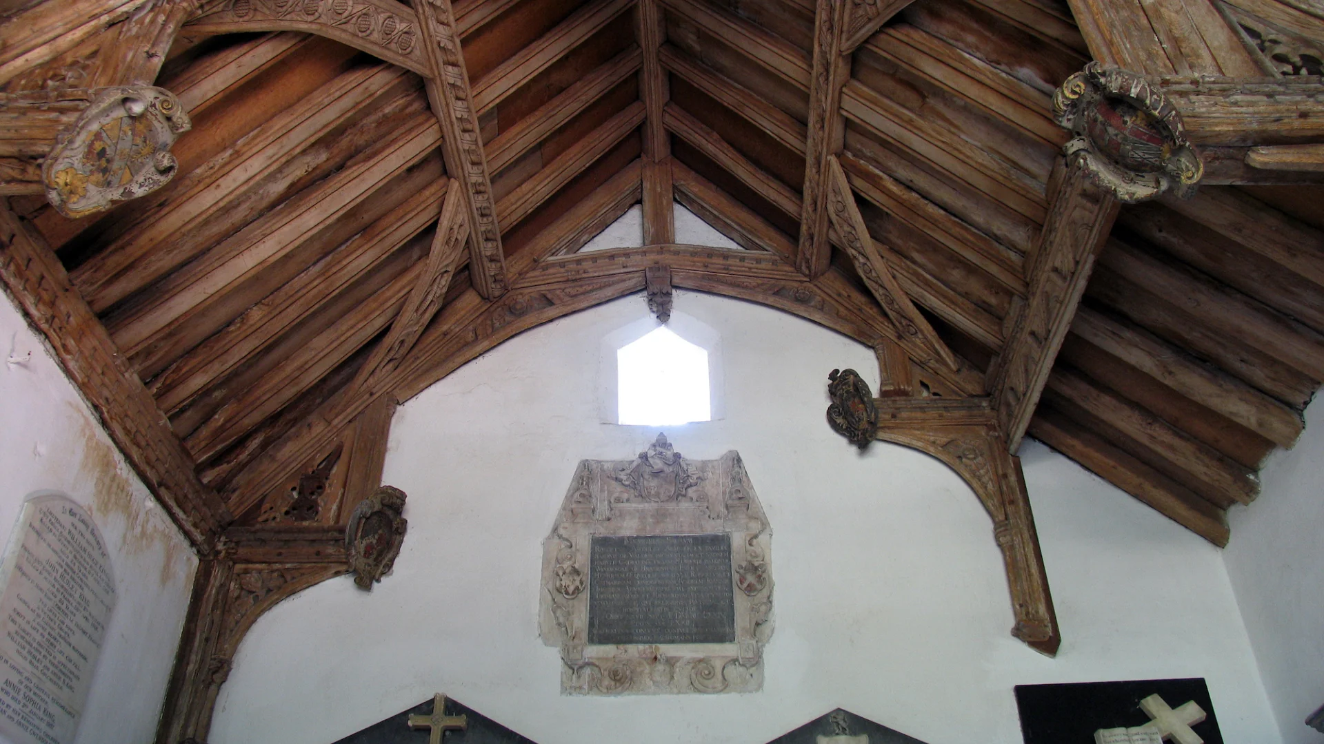 Superbly carved and coloured hammerbeam roof. Also visible are wall monuments