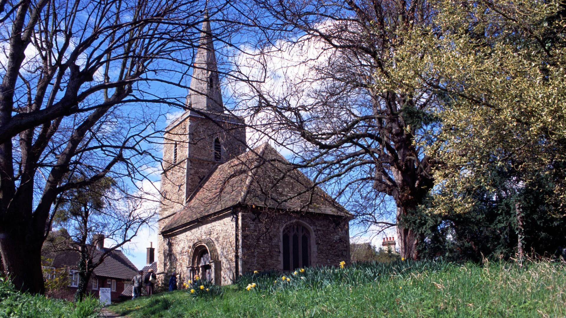 The tiny, tall-spired St Peter's is tucked away in among ancient trees