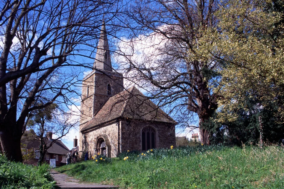 The tiny, tall-spired St Peter's is tucked away in among ancient trees