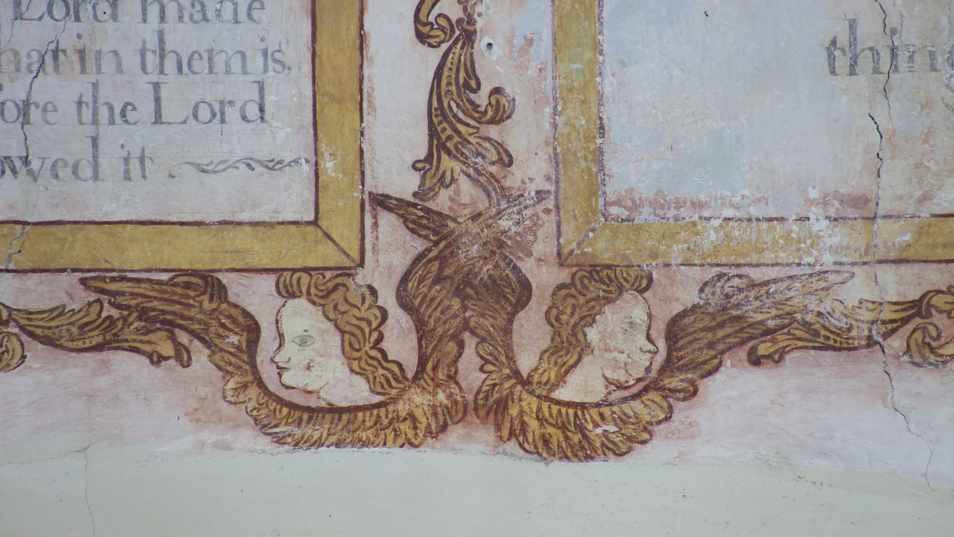 fine early seventeenth-century wallpaintings showing the Ten Commandments over the chancel arch, framed in twining leaves with enchanting cherubs; faces peering out.