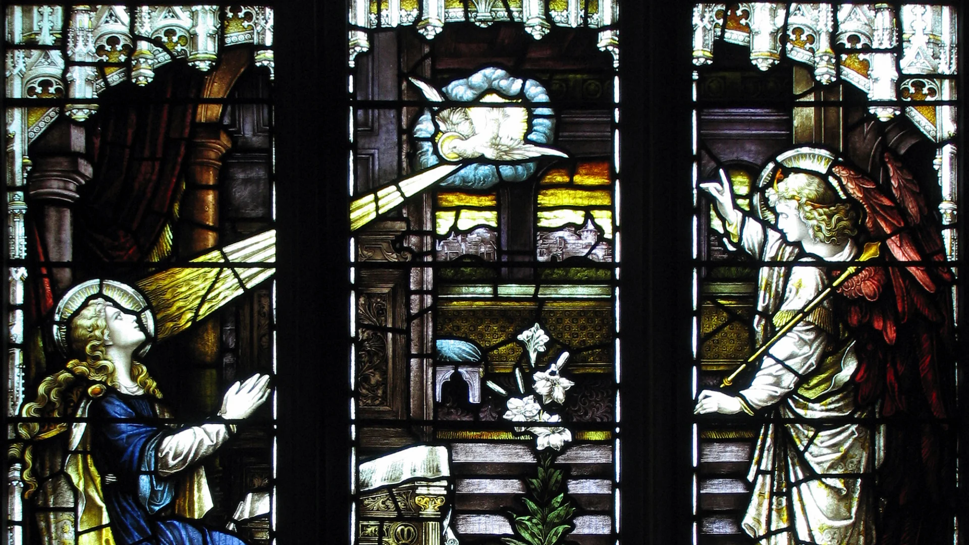 Impressive three panel stained glass showing kneeling woman, dove and then an angel from left to right.