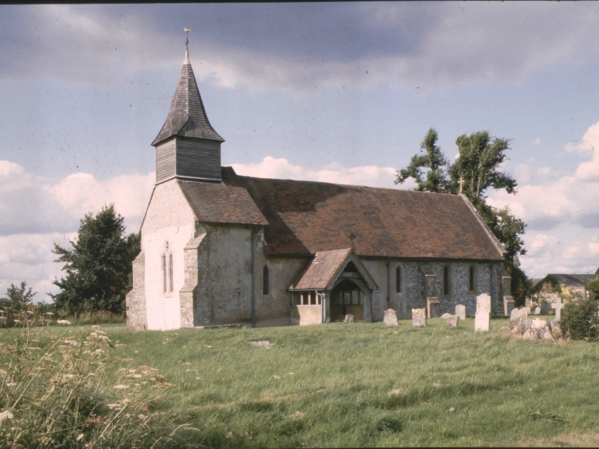 Church exterior with tall bell tower and red slanted roof