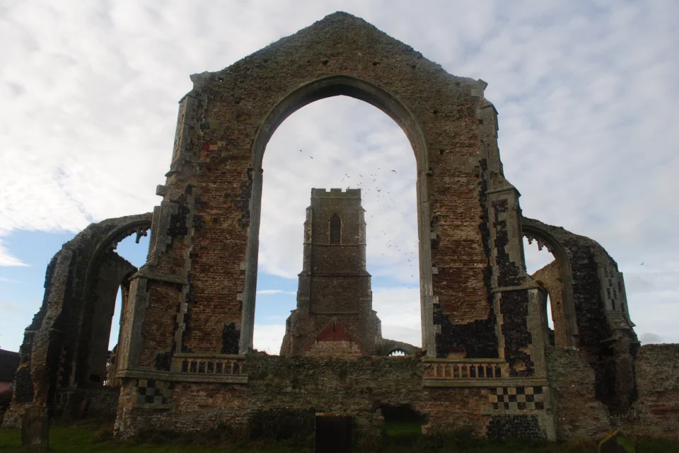 curtain of original walling surviving and tower visible through the ruinous archway