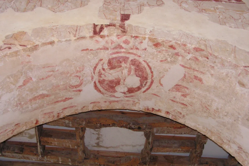 red wall paintings people and zig zag designs on an archway
