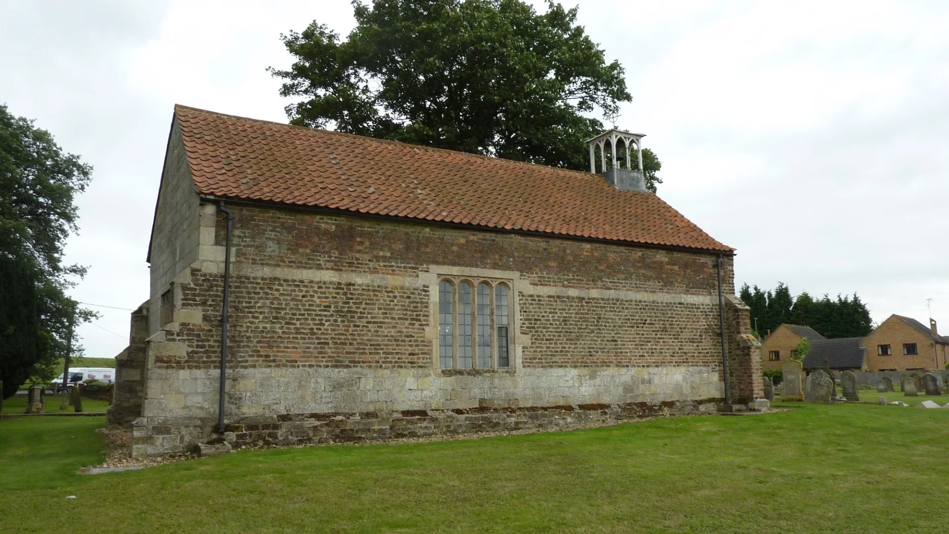 little and simple brick and stone chapel with red roof