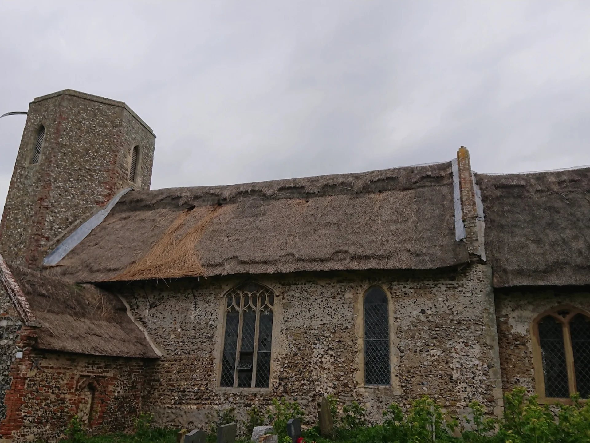 exterior with thatched roof and stone walls and tower