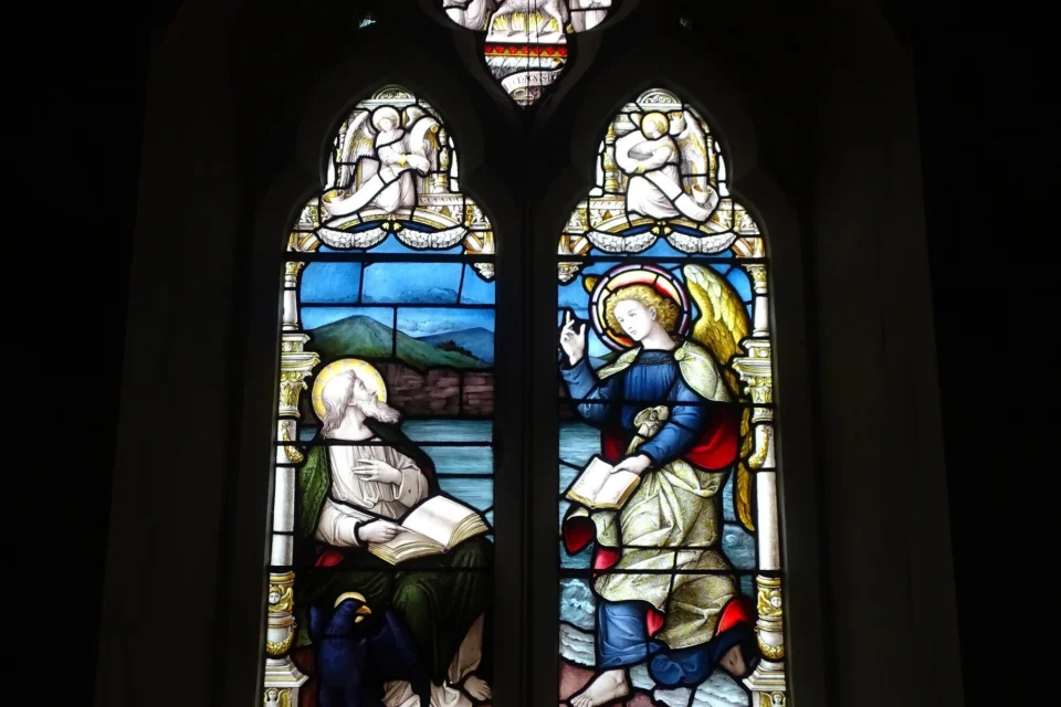 View of a colourful stained glass window depicting a biblical passage