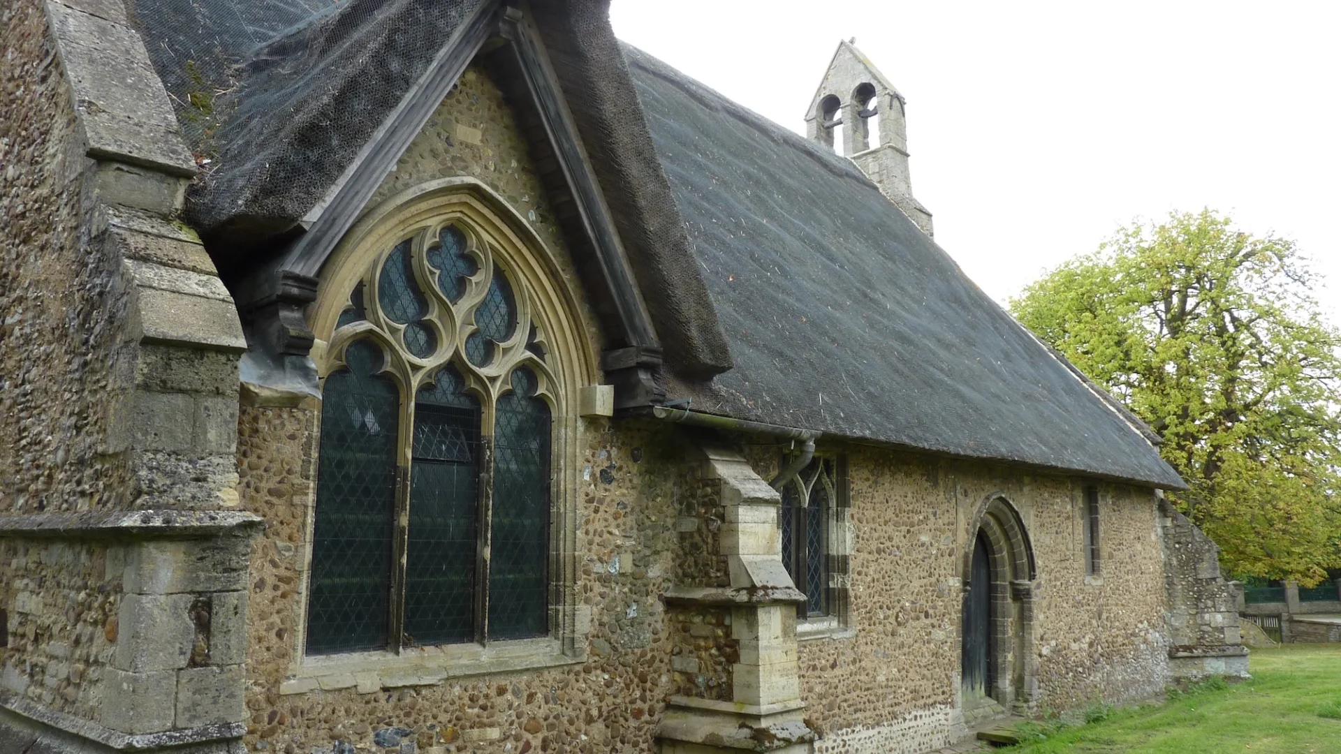 small thatched church with beautiful curved stone windows