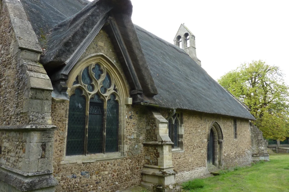 small thatched church with beautiful curved stone windows