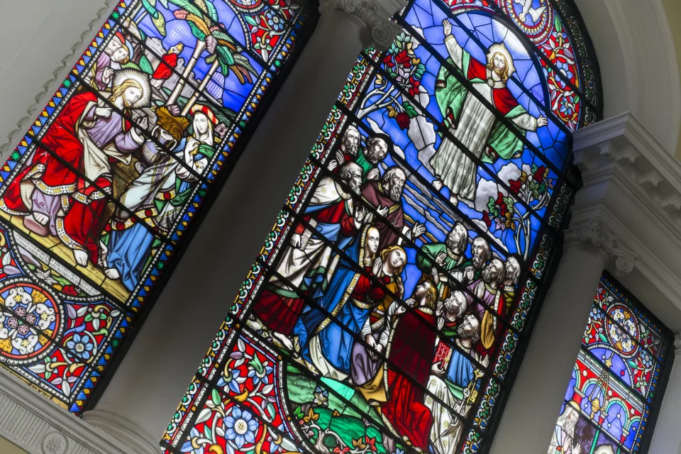 Three panel decorative stained glass window depicting Jesus