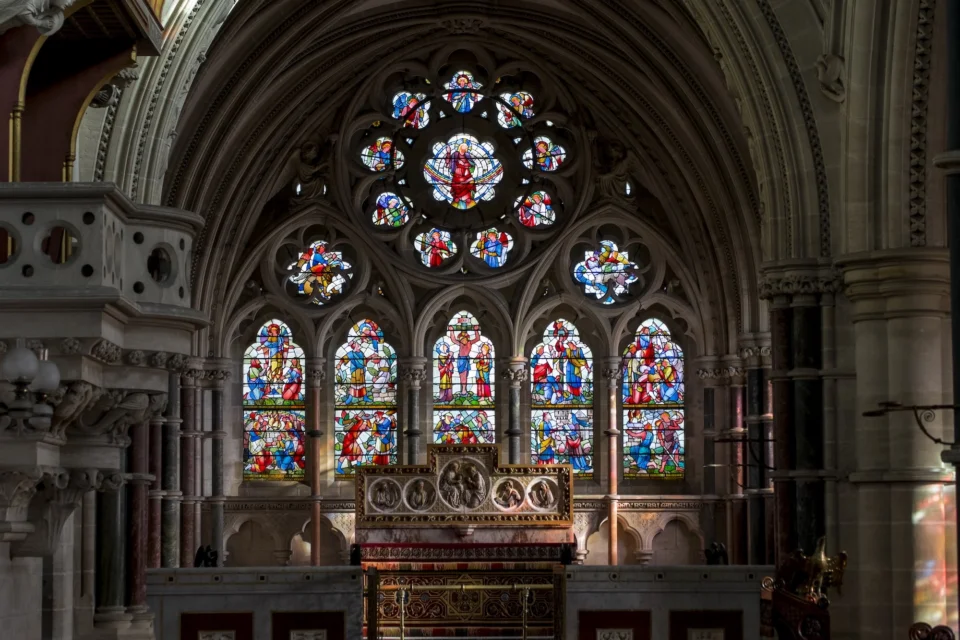 large stained glass with many colours behind the marble altar