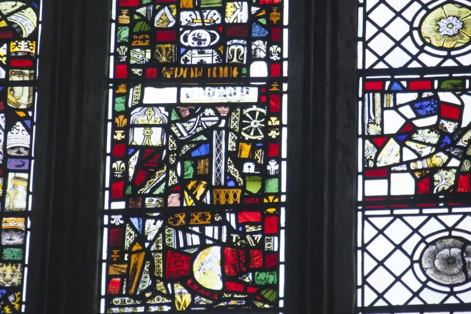 Jumble of old stained glass placed into a new window showing different colours and small fragments of different designs