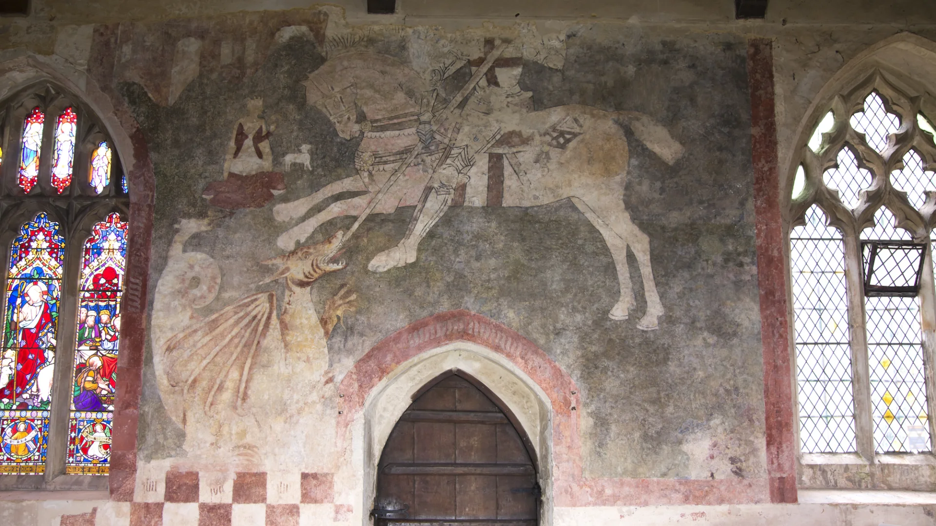 Medieval wall painting showing St George killing the Dragon also shows decorative stained glass and clear glass
