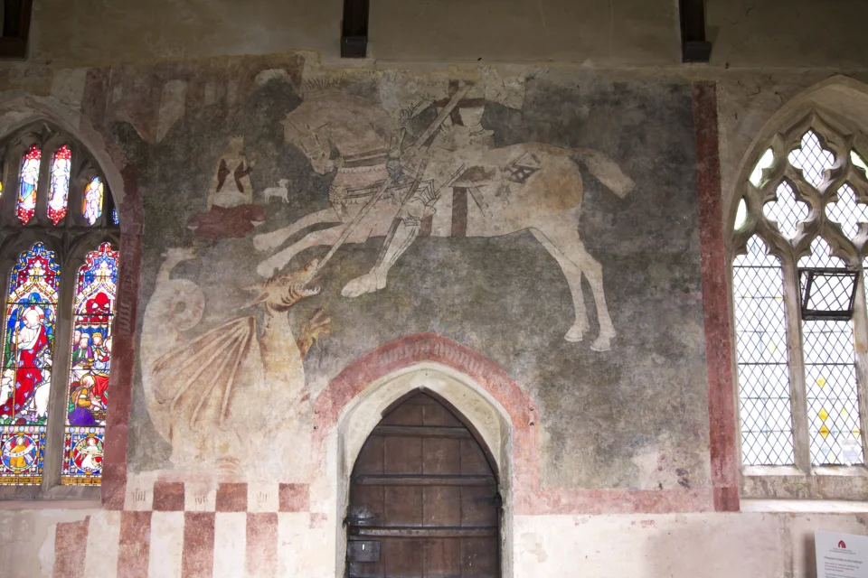 Medieval wall painting showing St George killing the Dragon also shows decorative stained glass and clear glass