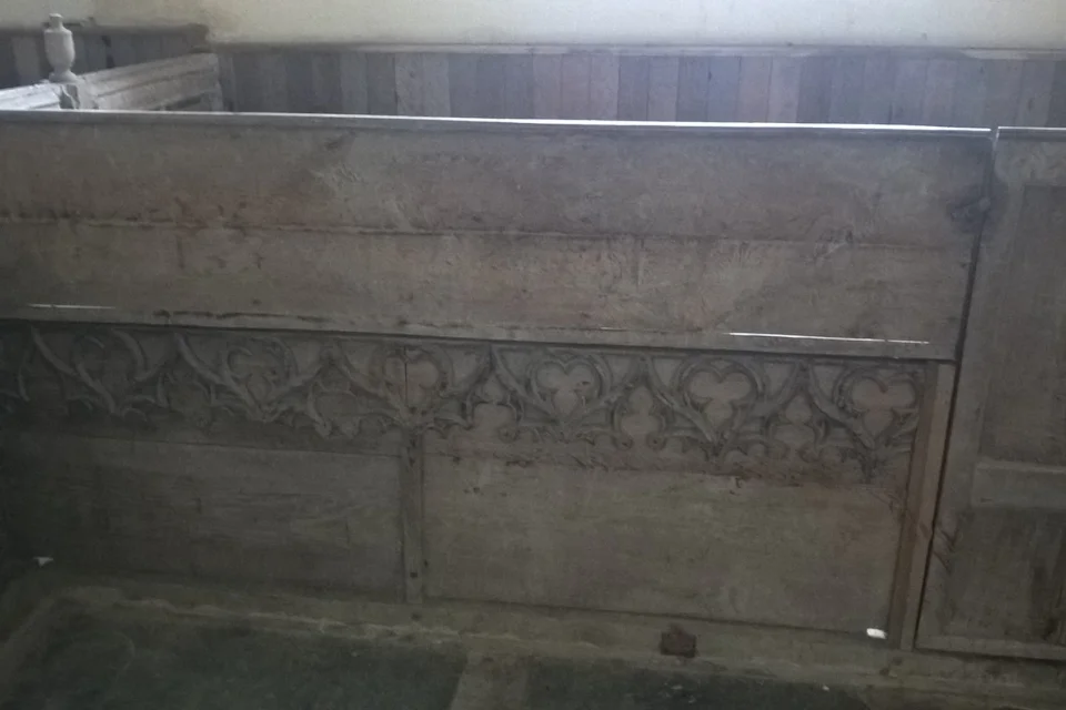 Box Pew with a line of decorative wood work three quarters of the way down.
