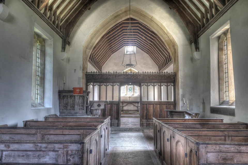 Pews facing the fifteenth-century screen in front of which is a raised wooden pulpit.