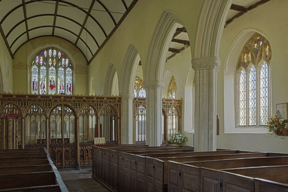 Interior of the church with pews, arches and decorated panels