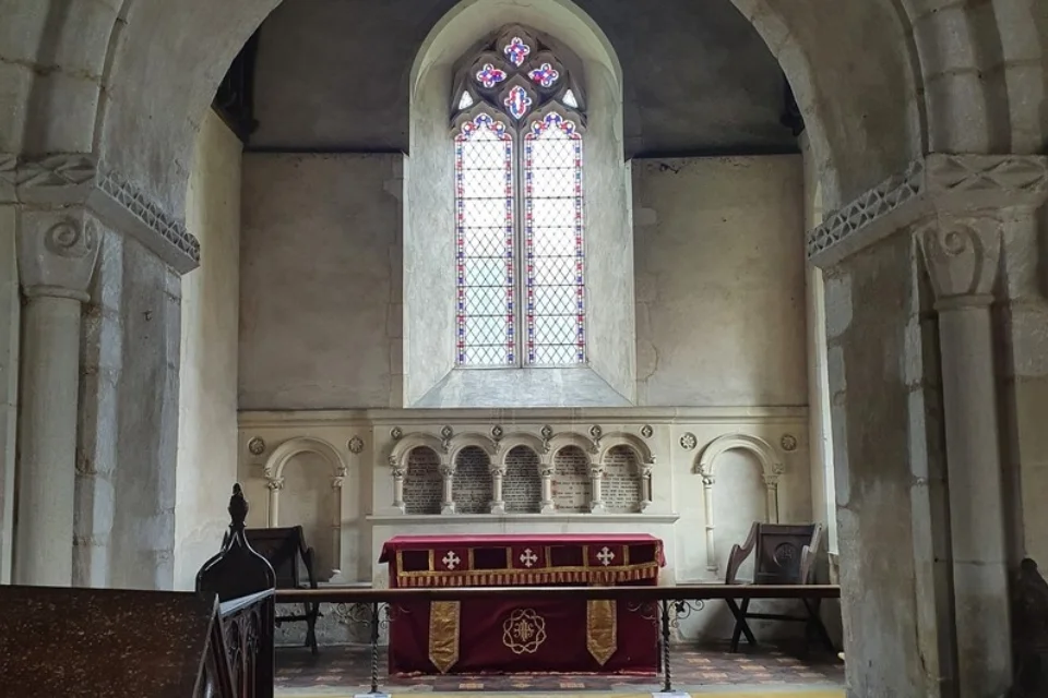 View of the altar with stone carved Baptismal font to its left