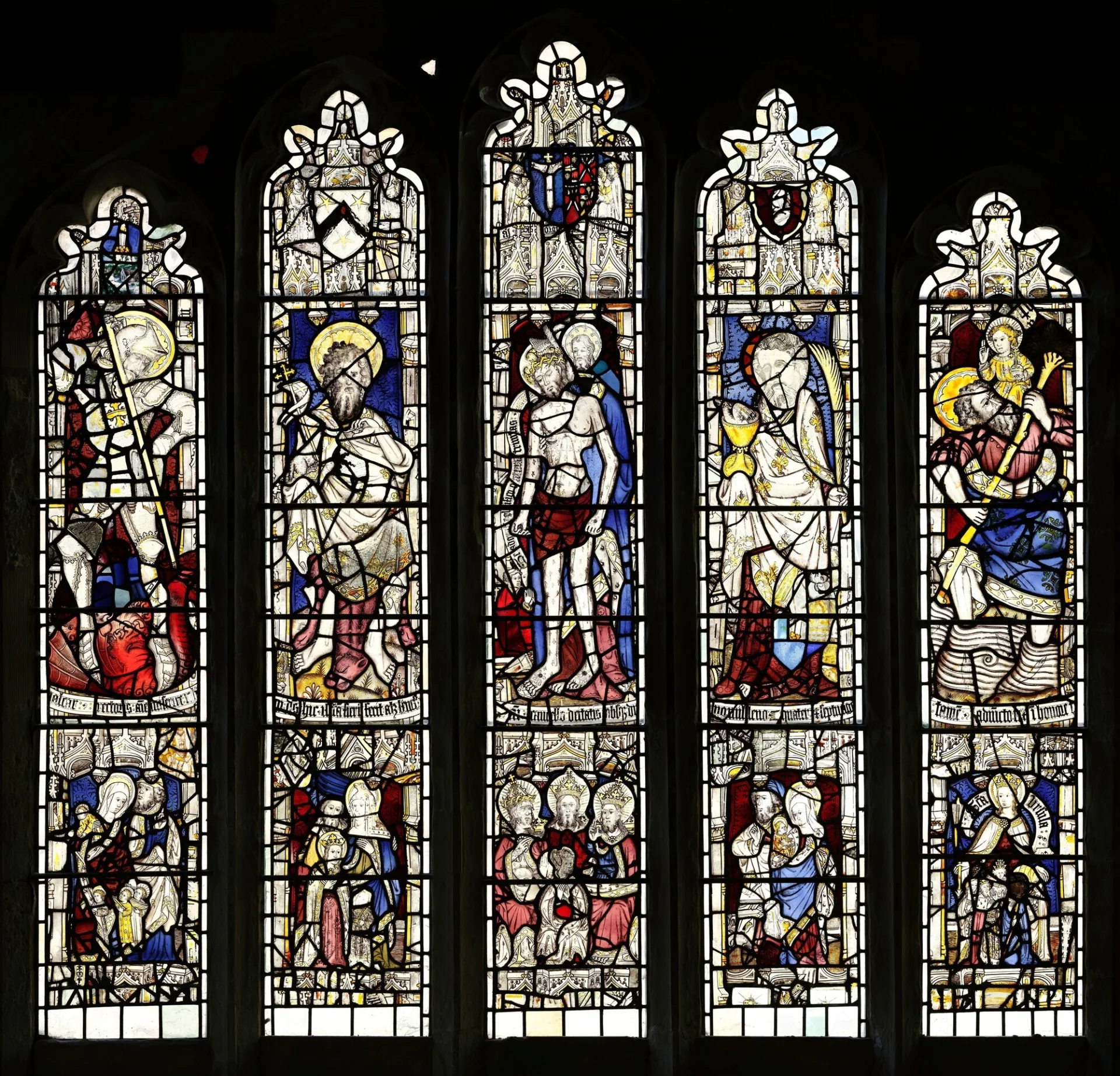 Five stained glass window panels depicting biblical passages