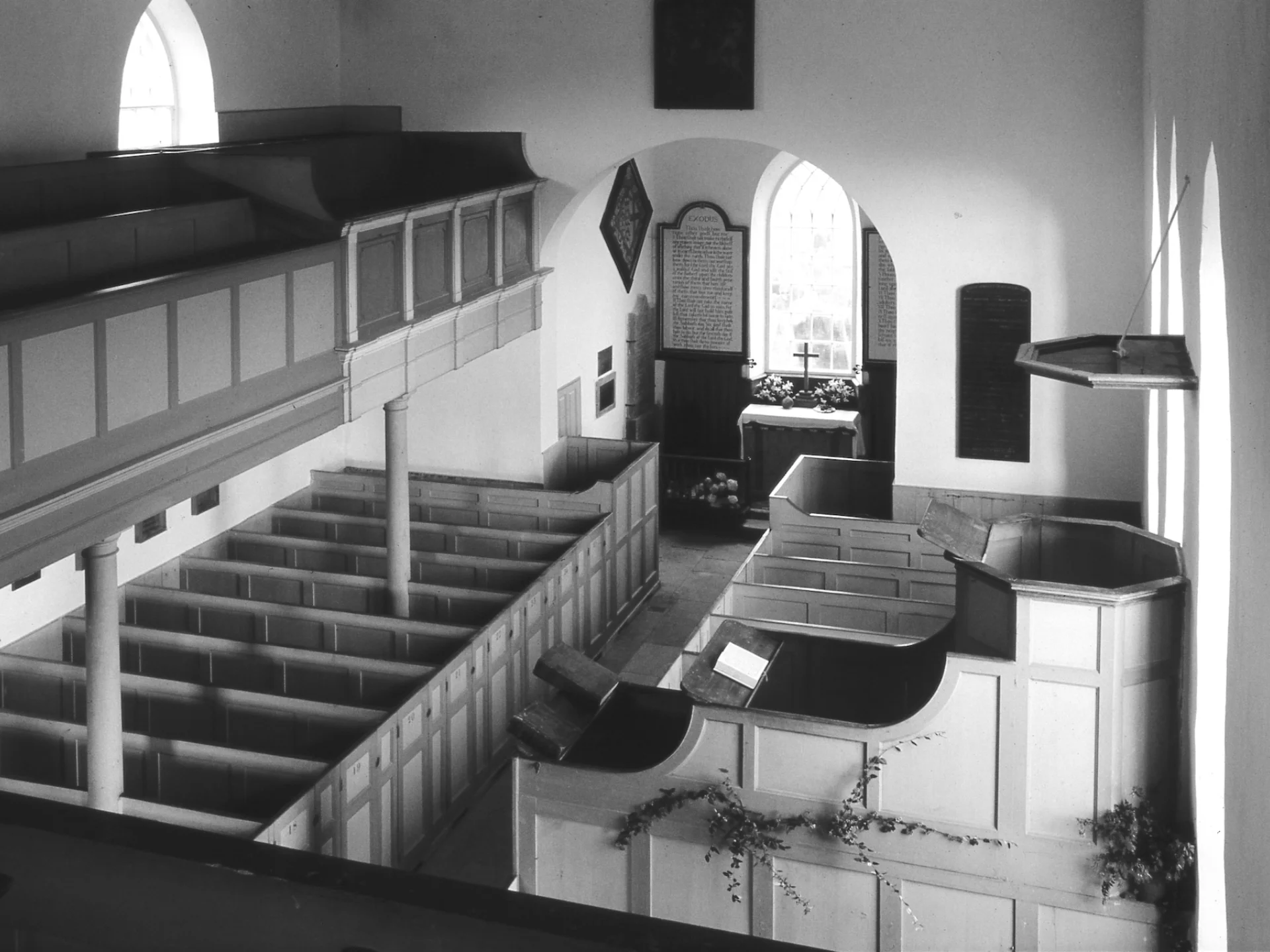 Church interior image in black and white showing box pews, a full-length gallery and a three-decker pulpit
