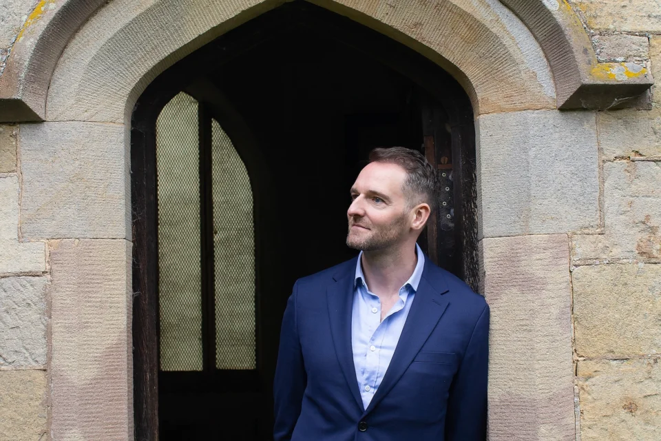 Portrait image of Greg Pickup under church archway