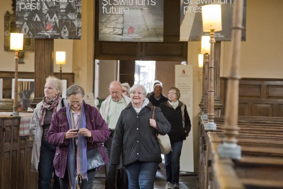 visitors enter the church looking excited, with promotional banners for the church hung behind them.