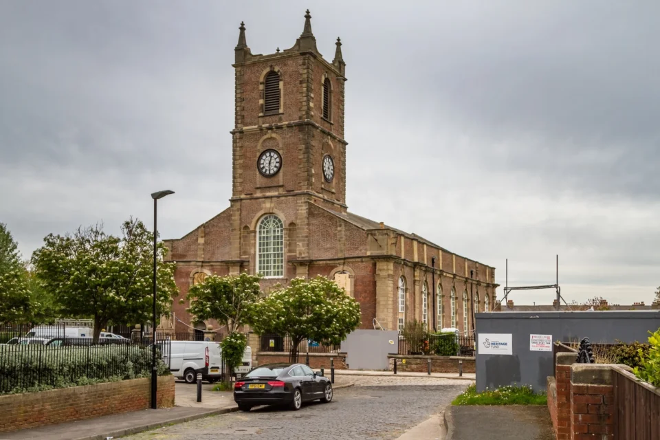 handsome brick and stone church exterior surrounded by roads with cars around