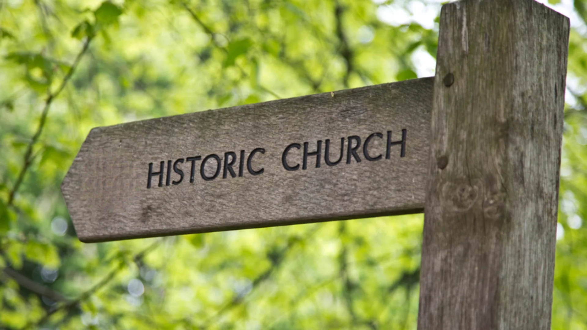 wooden sign with engraved title 'historical church' visible in the trees