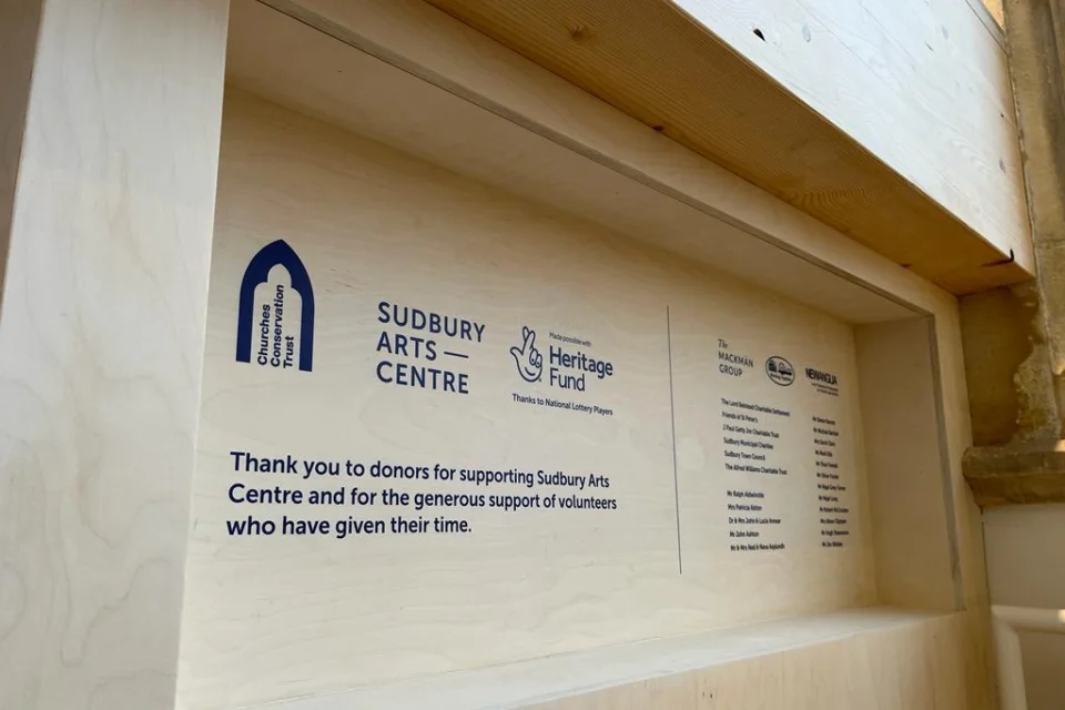 Sudbury arts centre sign indented into the wall with logos and the list of sponsors.